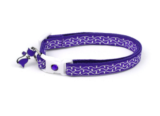 Adornos blancos en el collar morado del gato